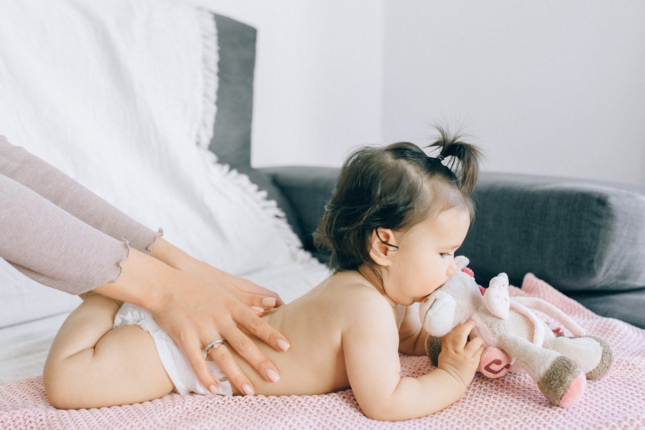 The Art of Drawing Readers In: Your attractive post title goes here A serene moment of a baby receiving a gentle massage while holding a plush toy, epitomizing peace and comfort.